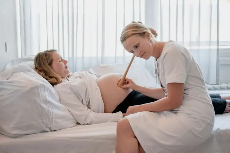 Jordemoder lytter til barnes hjertelyd på gravdi kvinde