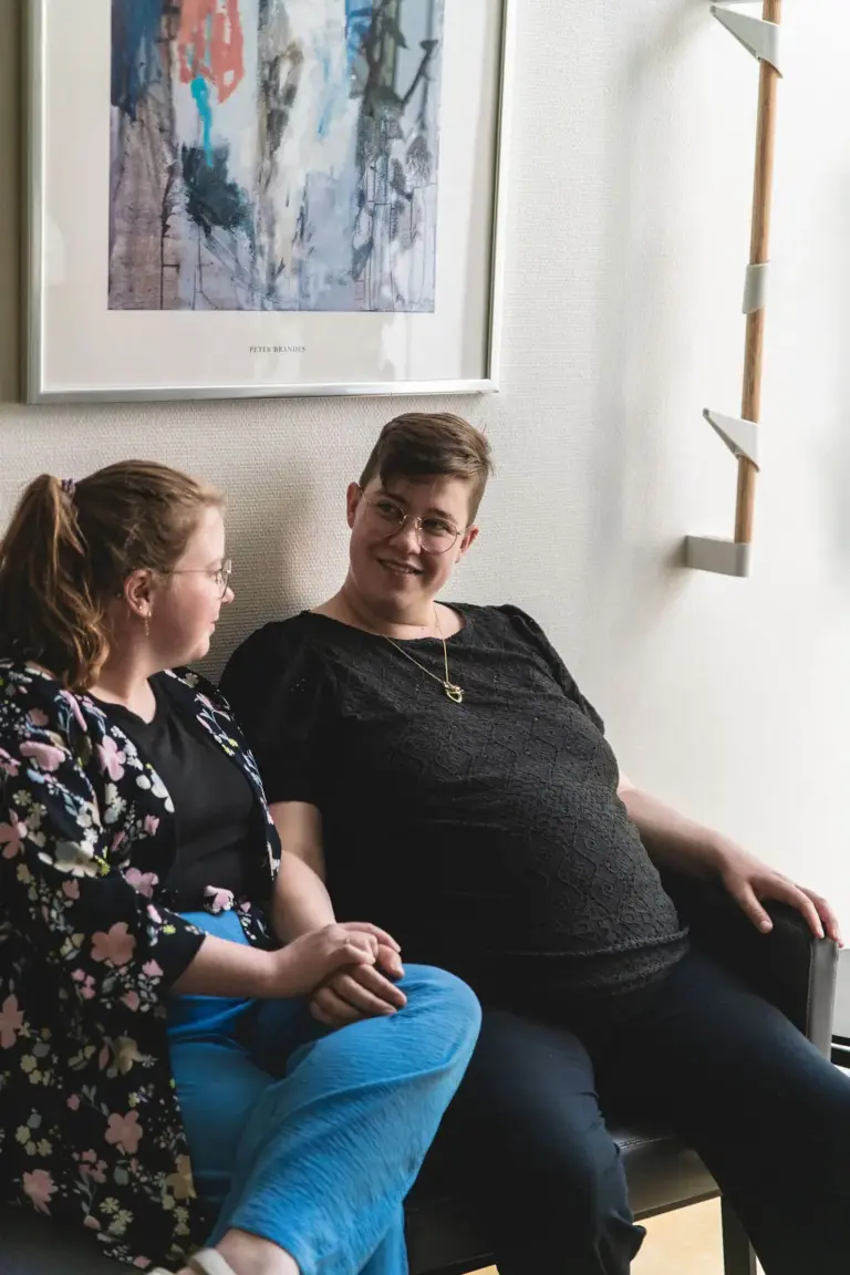 Gravid sidder i venteværelset med partner